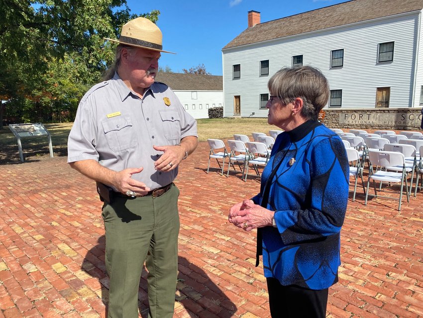 Gov. Laura Kelly, right, talks with Carl Brenner, chief of interpretation and resource management at the Fort Scott National Historic Site, during a visit to Fort Scott on Wednesday to announce funding for highway improvements.