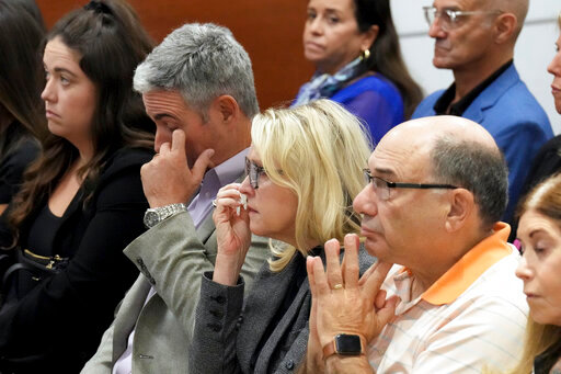 From left; Abby Hoyer, Tom and Gena Hoyer, and Michael Schulman react during the reading of jury instructions in the penalty phase of the trial of Marjory Stoneman Douglas High School shooter Nikolas Cruz at the Broward County Courthouse in Fort Lauderdale, Fla. on Wednesday, Oct. 12, 2022. The Hoyer's son, Luke, and Schulman's son, Scott Beigel, were killed in the 2018 shootings. Abby Hoyer is Luke Hoyer's sister. Cruz previously plead guilty to all 17 counts of premeditated murder and 17 counts of attempted murder in the 2018 shootings. (Amy Beth Bennett/South Florida Sun Sentinel via AP, Pool)