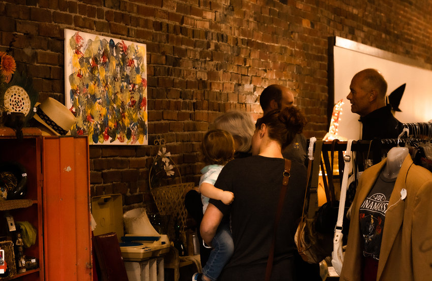 Gala attendees mingle and view the artwork created by children from the Family Resource Center on Thursday, Oct. 13. The gala was hosted at the Doggie Bag in downtown Pittsburg.