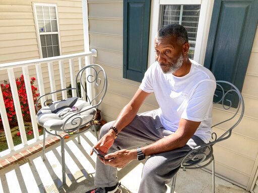Tracey Howard, husband of Nicole Connors who was fatally shot on Thursday, Oct. 13, 2022, sits on the porch of his Raleigh, N.C., home on Friday, Oct. 14. On Thursday, a 15-year-old boy fatally shot two people in the streets of a middle-class Raleigh neighborhood, then fled toward a popular walking trail where he opened fire, killing three more people and wounding two others in an attack that left the city reeling and authorities searching for a motive, police said. (AP Photo/Allen G. Breed)