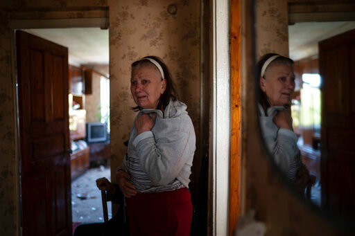 Tetyana Lazunko stands in her apartment that was damaged after a Russian attack at a residential area in Zaporizhzhia, Ukraine, Sunday, Oct. 9, 2022. (AP Photo/Leo Correa)