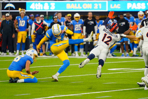 Los Angeles Chargers place kicker Dustin Hopkins (6) kicks the game winning field goal as Denver Broncos wide receiver Montrell Washington (12) tries to block it during the second half of an NFL football game, Monday, Oct. 17, 2022, in Inglewood, Calif. The Chargers defeated the Broncos 19-16 in overtime. (AP Photo/Mark J. Terrill)