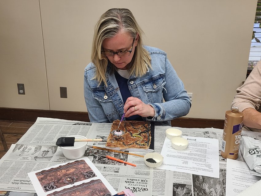 Lisa Dunn puts the finishing touches on her Hocus Pocus themed journal at the Pittsburg Public Library&rsquo;s iCraft event for teenagers and adults on Wednesday. The library held two Hocus Pocus craft events, one for children and one for adults and teenagers. Dunn said this was the second iCraft event she has attended.