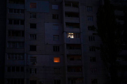 A man looks out from a window in a building damaged by fighting between Ukrainian and Russian forces in Borodyanka, Kyiv region, Ukraine, Friday, Oct. 21, 2022. Russia has declared its intention to increase its targeting of Ukraine's power, water and other vital infrastructure in its latest phase of the nearly 8-month-old war. Ukrainian President Volodymyr Zelenskyy says that Moscow's forces have destroyed nearly a third of the country's power stations since Oct. 10. (AP Photo/Emilio Morenatti)