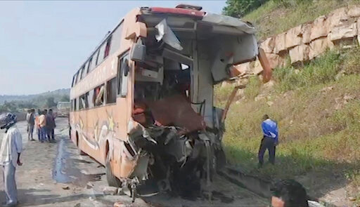 This image from video shows the mangled remains of a bus that collided with a truck on a highway in Rewa district of Madhya Pradesh state, India, Saturday, Oct.22, 2022. More than a dozen people were killed and dozens were injured in the accident. (K K Productions via AP)