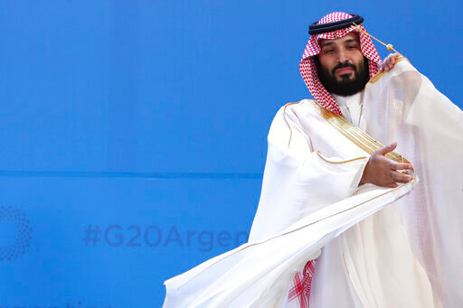 FILE - Saudi Arabia's Crown Prince Mohammed bin Salman adjusts his robe as leaders gather for the group at the G20 Leader's Summit at the Costa Salguero Center in Buenos Aires, Argentina, Nov. 30, 2018. Saudi Arabia's powerful 37-year-old crown prince will not attend an upcoming summit in Algeria after his doctors advised him not to travel, the Algerian presidency said early Sunday, Oct. 23, 2022. (AP Photo/Ricardo Mazalan, File)