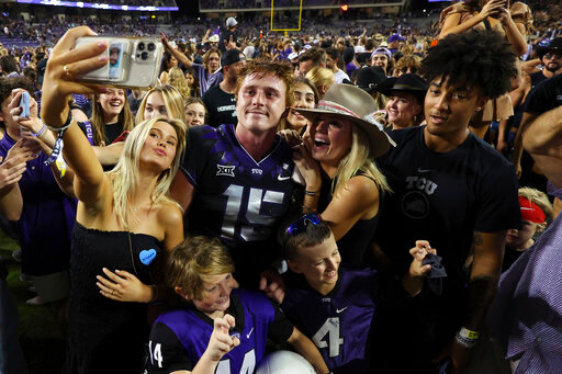 Fans try to get a photo with TCU quarterback Max Duggan (15) after the team's win over Kansas State in an NCAA college football game Saturday, Oct. 22, 2022, in Fort Worth, Texas. (AP Photo/Richard W. Rodriguez)