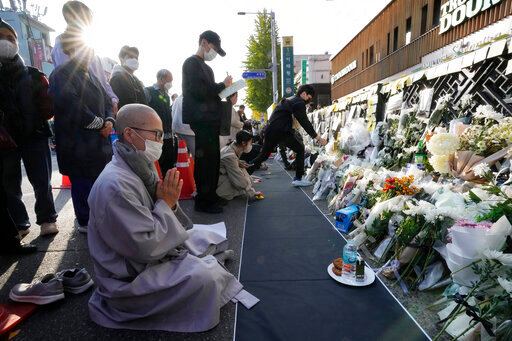 A Buddhist monk prays for victims of a deadly accident following Saturday night's Halloween festivities on the street near the scene in Seoul, South Korea, Tuesday, Nov. 1, 2022. (AP Photo/Ahn Young-joon)