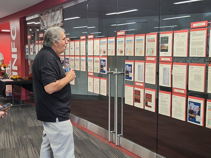 Dean of Kelce College of Business Paul Grimes views the display of journal articles that were published by faculty of PSU this year at the 39th Annual University Authors Reception at Axe Library on Thursday.