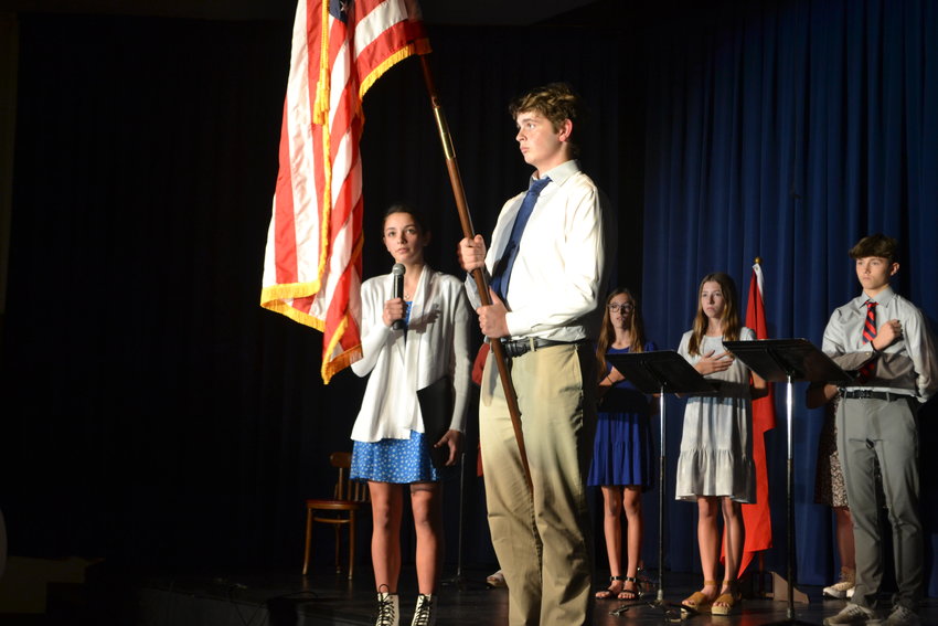 St. Mary&rsquo;s Colgan junior Alex Carson, right, holds the flag as Dani Yaghmour sings &ldquo;The Star Spangled Banner&rdquo; during SMC&rsquo;s Veterans Day program on Friday.