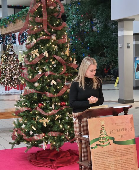 Mount Carmel Foundation Executive Director Johnna Norton reads the names of those being honored with ornaments on the Remember Me Tree on Monday evening.
