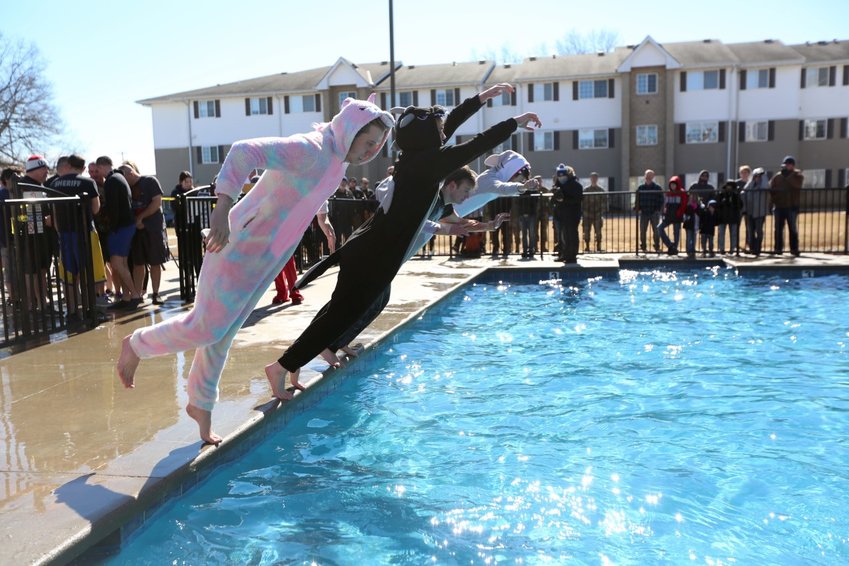 Costumed plungers dive into the ice-cold pool at Crimson Villas during the 2022 Pittsburg Polar Plunge.