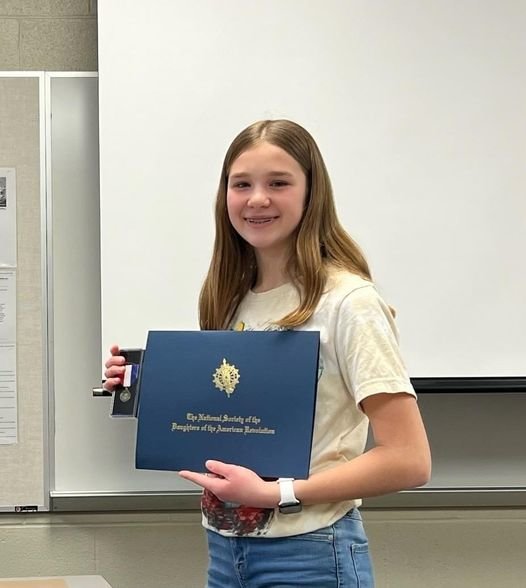August Mooneyham, an 8th grader at Girard Middle School, holds up her certificate and the bronze medal she earned at the American History Essay Contest sponsored by the Daughters of the American Revolution on Feb. 20. Mooneyham won the contest with her essay about the Second Continental Congress.&nbsp; &nbsp;