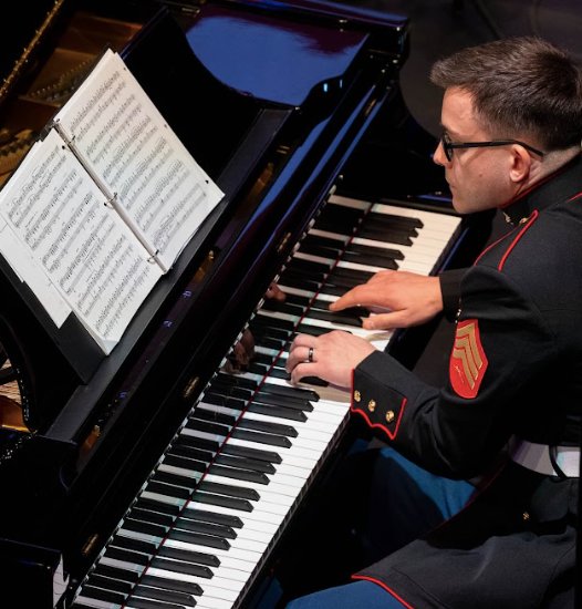 Marine Corps Sergeant Sean Carmichael tickles the ivories during Sunday night&rsquo;s concert, a call-back to the earliest traditions of Navy when the only Naval musicians were the drummers and buglers of the Marine detachments assigned to ships&rsquo; companies.