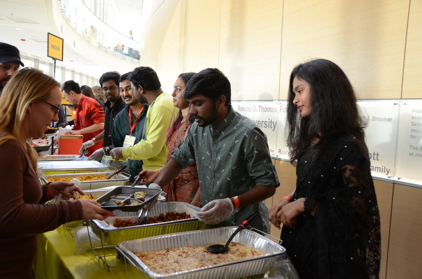 Students from India serve cuisine from their county at the International Food and Culture Fair on Saturday at the Bicknell Family Center for the Arts.