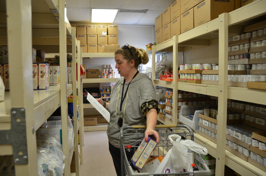 Wesley House Food Procurement Manager Whitney Malone gathers items requested by a client at the Wesley House Food Pantry.