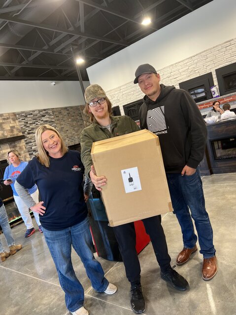 Tara Roberts of Fireplace Creations, presents Dallas Garza and his brother Dustin with a new pizza oven.