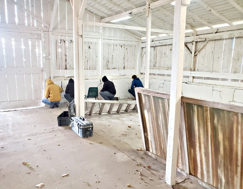 Students from Fort Scott Community College and Southeast Kansas   Career and Technical Education Center help to restore the barns at the Crawford County Fairgrounds in late 2022.