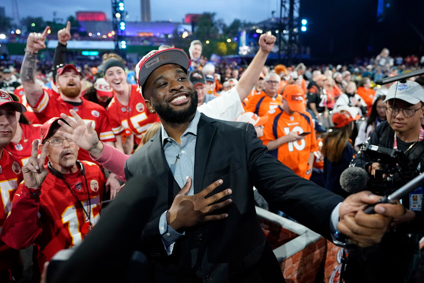 Former Kansas State defensive lineman Felix Anudike-Uzomah takes a selfie with fans during the second round of the NFL football draft, Friday, April 28, 2023, in Kansas City, Mo. Anudike-Uzomah was picked by the Kansas City Chiefs in the first round. (AP Photo/Charlie Riedel)