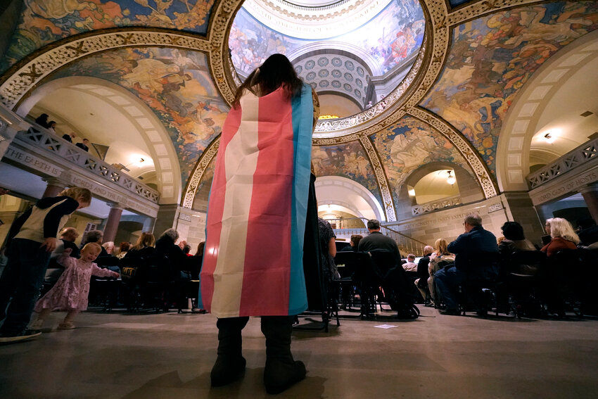 Glenda Starke wears a transgender flag as a counter protest during a rally in favor of a ban on gender-affirming health care legislation, March 20, 2023, at the Missouri Statehouse in Jefferson City, Mo.
