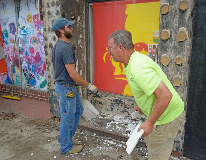 Orin Myer, left, and Clint Center, right, from Home Center Construction, clear out debris from The Finishing Touch's old fa&ccedil;ade Monday afternoon at 622 N Broadway. According to Center, the storefront's new fa&ccedil;ade is expected to be completed in the coming weeks.