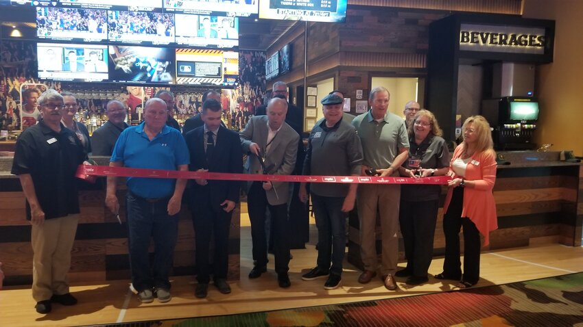 Jeff McKain (center), general manager of Kansas Crossing Casino, prepares to cut the ribbon Wednesday morning to mark the opening of Caesars Sportsbook inside the casino. JIM HENRY / MORNING SUN STAFF