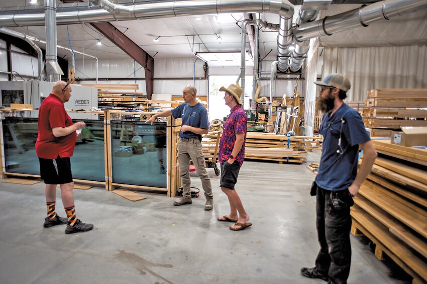 PSU Wood Product Manufacturing graduate Bob Holloway (center) shows Pitt State President Dan Shipp the workings of the unique company he started in Colby, Kansas, while fellow Gorilla Kyle McMillan (right) and Shipp's cycling partner Darrell Pulliam (left) look on.