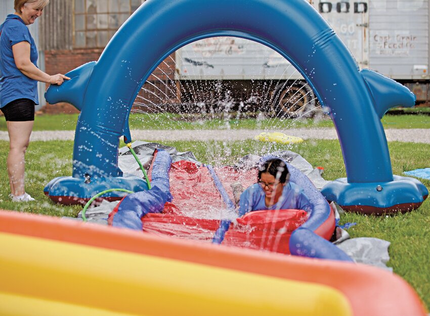 Fun Zone Depot employee and Pittsburg High School student Mia Conrad glides down the slip &amp; slide at the &lsquo;Fun Zone Summer Splash&rsquo; held on Wednesday, which also featured water balloons, musical chairs and dodgeball. The event, located at 104 N. Locust in Pittsburg, is scheduled to be held from 2 to 5 p.m. on June 28, July 12 and July 26.