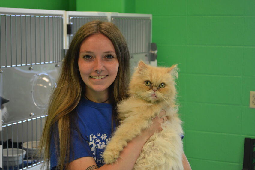 Kelsey Keeney poses with Garfield, one of the mascots of the SEK Humane Society. Living his entire life at the Humane Society, 11-year-old Garfield is known as &ldquo;the face of the place&rdquo; but is not up for adoption during this weekend&rsquo;s 50th anniversary celebration.