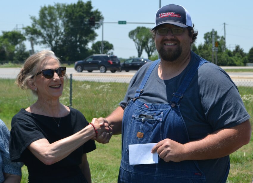 Linda Roberts, Chair of the Miners&rsquo; Hall Museum 2024 Board of Trustees, presents a check to Derrick Tilton, of Tilton and Sons, a family-owned business specializing in moving extra-large equipment and buildings. Tilton&rsquo;s company will be responsible for the relocation of a Page 618 walking dragline, Number 193, to Ginardi Corner south of Franklin at the intersection of US-69 and K-47.
