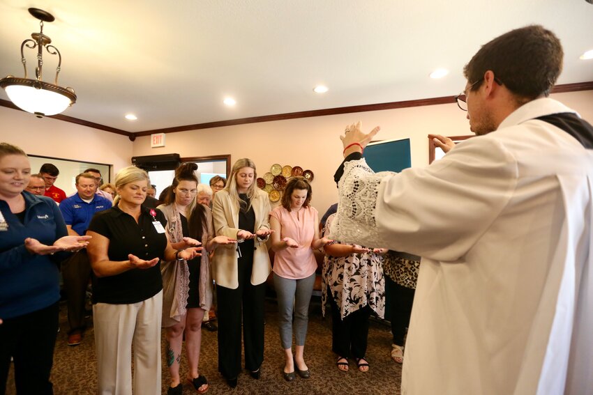 St. Mary&rsquo;s Colgan School Chaplain Fr. Andrew Labenz blesses the workers of Mercy Clinic Family Medicine during a grand opening on Wednesday.