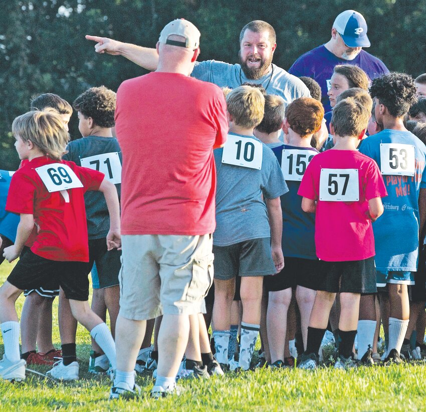 Pittsburg coach Josh Lattimer fires up the players during a break in the youth football camp Tuesday at the high school practice field.