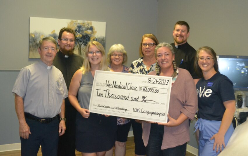 Representatives from the several Crawford County Lutheran Churches present a $10,000 check to Vie Women&rsquo;s Clinic in Pittsburg on Monday afternoon on behalf of the Lutheran Church Missouri Synod. In attendance were (front row) Pastor Theodore Cook, Ashley Kmiec, Frances Oldweiler, and Amanda Lehman; (middle) Pastor Caleb Stoever, Debbie Lehman, and Joyce Hageman; (back) Paster Michael Hofmann.