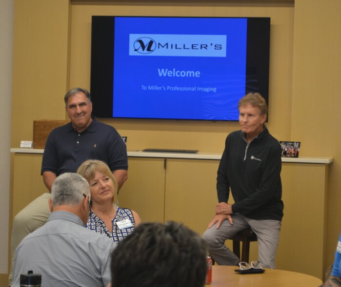 Joe Dellasega (left) and Richard Miller (right), son of founder William Miller and current CEO of Miller&rsquo;s Professional Imaging, talks with the Leadership Kansas Class of 2023 about the history of the business. Class members received a tour of the facility and were shown the myriad of products Miller&rsquo;s produces.