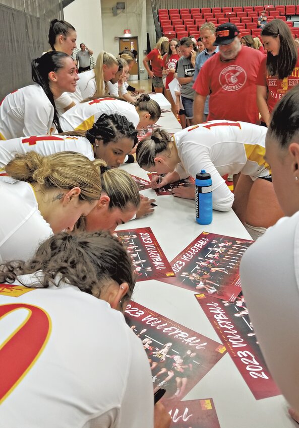 Pittsburg State volleyball players sign photos after Saturday&rsquo;s Red and White scrimmage at John Lance Arena.
