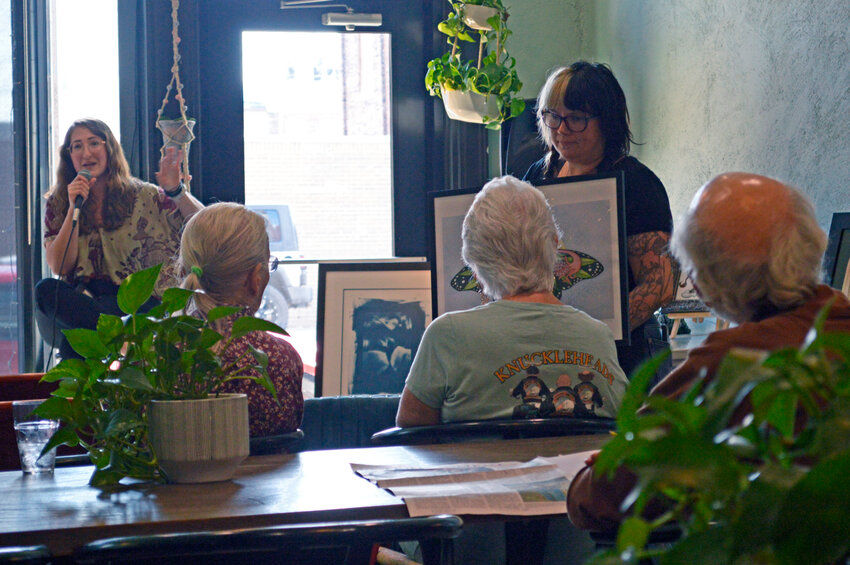 Local artist Liz Darling (left) &mdash; who uses watercolor, ink, and various other media for her illustrative, organic paintings that often feature fungi, lunar imagery, and the female body &mdash; discusses the creation of some of her paintings during a panel discussion Saturday, Sept. 9 at Toast in Pittsburg. Her works were shown to those who attended by Toast co-owner Heather Lynn Horton (right).