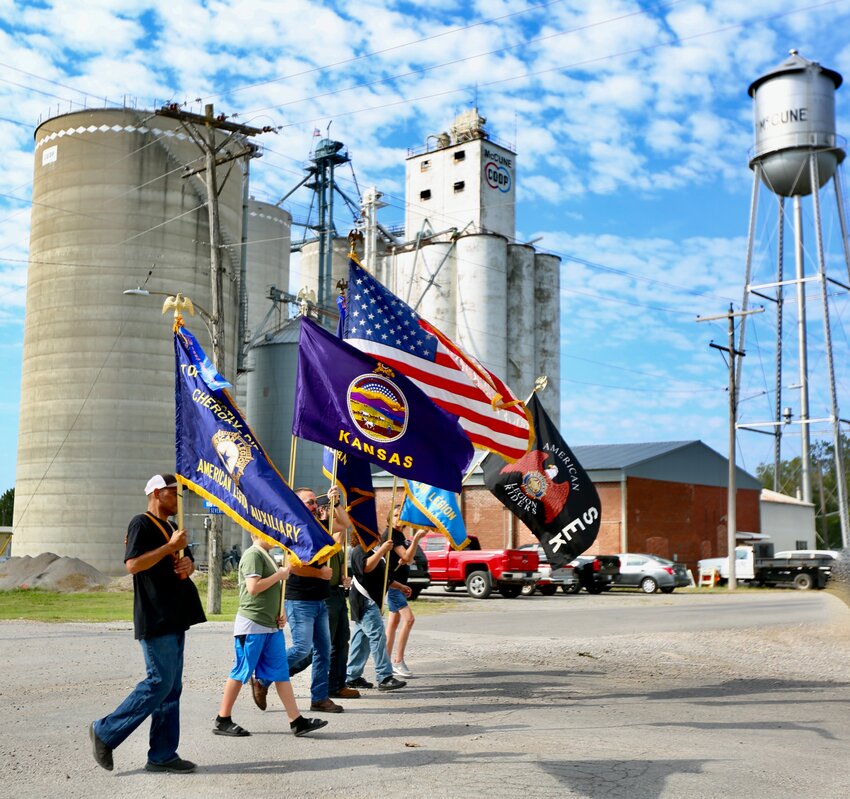 Members of the McCune community, Priestly-Ridley American Legion Post 35 and Southeast Kansas American Legion Riders showcase their respective flags during the beginning of Saturday&rsquo;s parade at the 77th annual McCune Fall Festival.