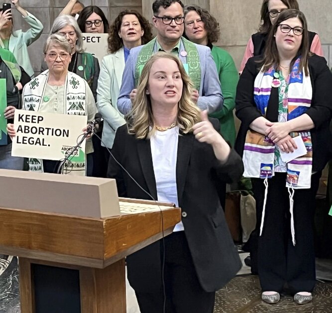 Nebraska state Sen. Megan Hunt addresses a crowd Wednesday, April 12, in the Nebraska state Capitol rotunda in Lincoln, Neb. A judge has dismissed a defamation lawsuit Wednesday, filed by Hunt against a conservative that labeled her a child groomer and sexual abuser in online posts.