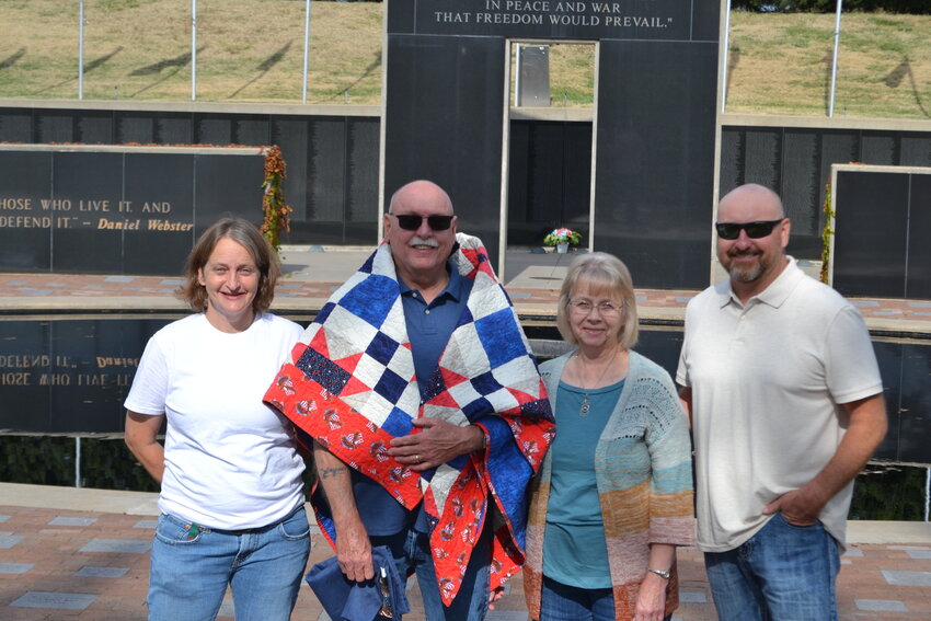 U.S. Navy veteran Wayne Reinhart poses with his family after receiving a Quilt of Valor on Saturday at the Pittsburg State Veterans&rsquo; Memorial for his service from 1971 to 1975.&nbsp;