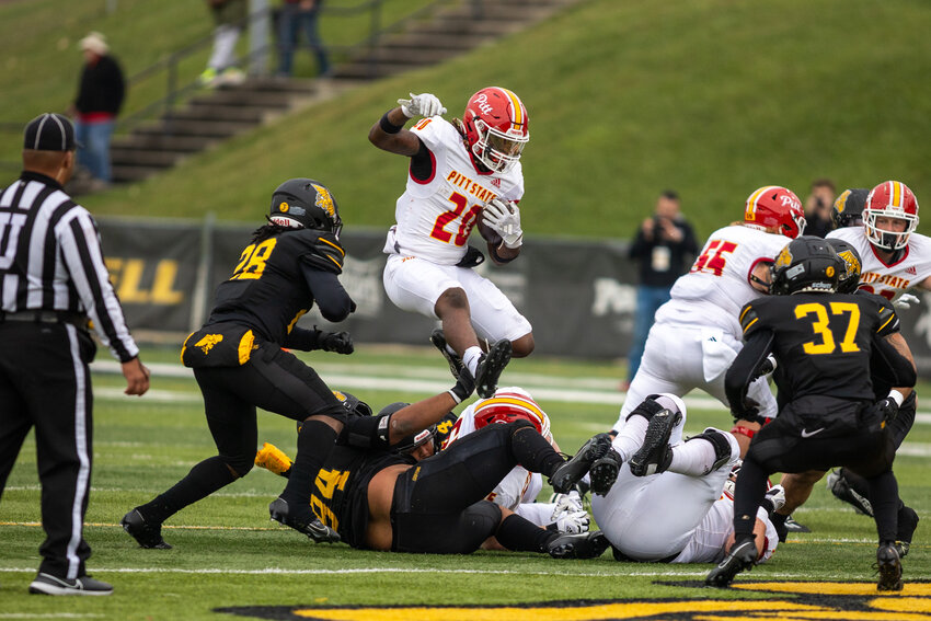 Pittsburg State's Cleo Chandler jumps over some players for a gain during the game at Missouri Western on Nov. 4.