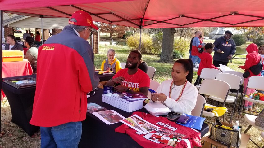Former Pittsburg State All-American John Brown visits with a Gorilla fan before the game against Central Oklahoma on Nov. 11. John's wife, Akia, is seated next to him.
