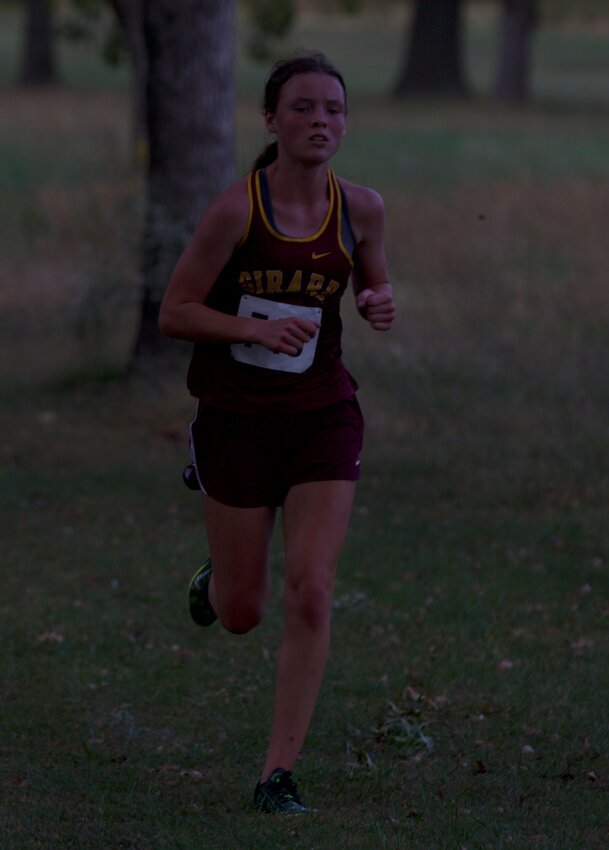 Girard freshman Kennedy Keller runs away from the field Oct. 12 in the CNC League meet. Keller won a league title and helped the Trojans finish third at regional and eighth at state.