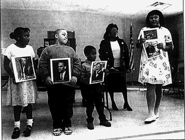 Joyce Almond watches as area children, from left, Cheese Hall, Cameron Burger, Taylor Madison, and Amanda Lomax, present a program on African American leaders during a Black History Month celebration.&nbsp;