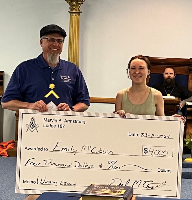 Each year the Kansas Masonic Grand Lodge holds an Essay writing contest. This year, Dan Eckstein (left) helps Emily McCubbin (right) of Frontenac hold up the $4000 prize check. The local Lodge (Marvin A. Armstrong #187) presented her with her winnings at their most recent stated meeting.&nbsp;