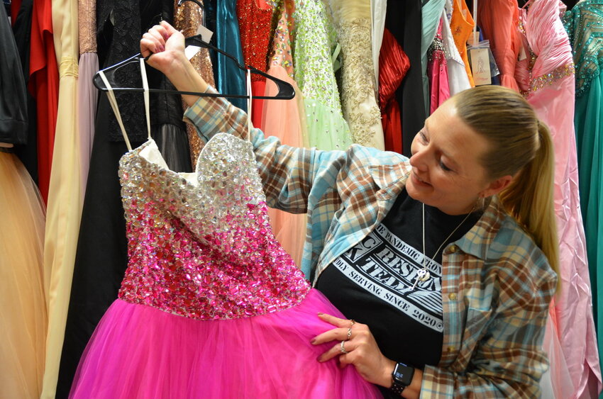 CHC/SEK Patient Education and Support Manager Julie Laverack places a donated prom dress on the hanger prior to last year&rsquo;s Fairy Godmother Boutique.