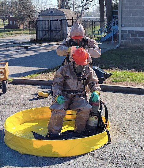 Firefighters conduct a decontamination drill after being exposed to simulated hazardous materials during a training exercise at Pittsburg State University last week.
