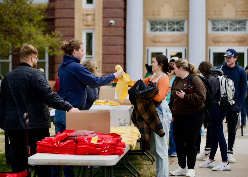 Pittsburg State University students grab their free shirts as part of Wednesday&rsquo;s &ldquo;Apple Day&rdquo; celebration held in the front lawn of Russ Hall.