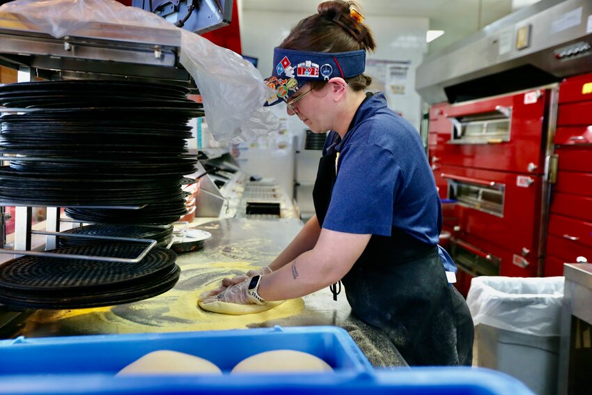 Domino&rsquo;s Pizza shift leader Allie O&rsquo;Malley prepares a pizza Thursday afternoon as the pizza restaurant chain helped raise money for Wesley House, an outreach mission for people in crisis founded by the Pittsburg First United Methodist Church. Throughout Thursday, by using a coupon or code, those who ordered Dominos had 25 percent of the total order donated back to the Wesley House to help its food pantry and those facing food insecurity.