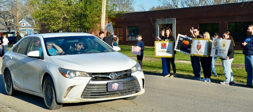 Eva Maxton and her family make their way down Magnolia Street in Cherokee Friday morning as Southeast Middle School students, staff, and community members hold signs and cheer on Maxton as she heads to Children&rsquo;s Mercy in Kansas City for treatment.