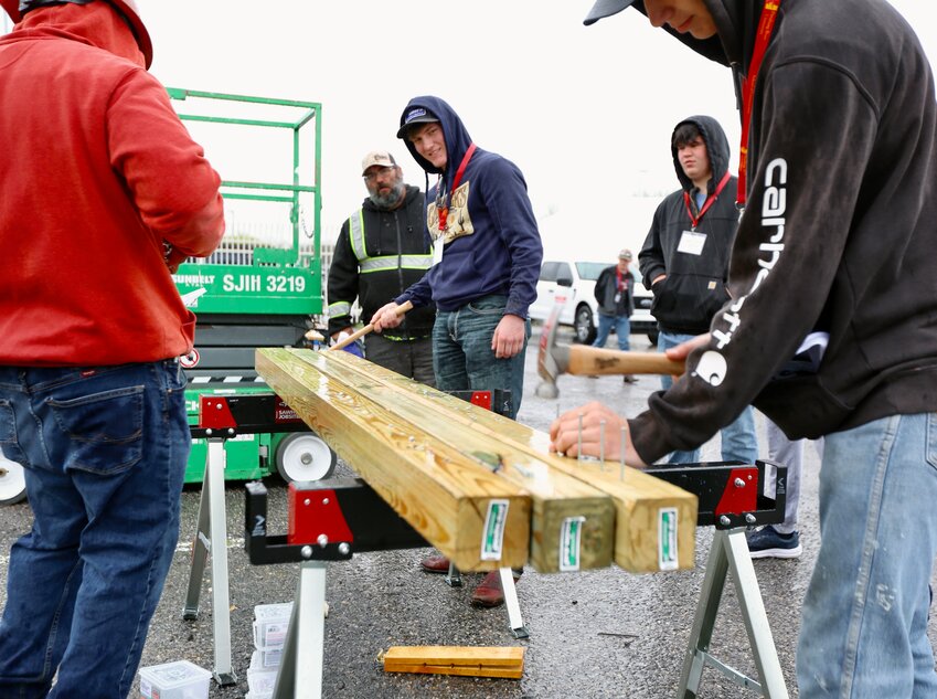 Several students tested their nail driving skills in the wet weather during the second day of the Pittsburg State University School of Construction&rsquo;s annual expo, which hosted more than 300 high schoolers and 100 vendors.